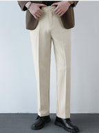 Pantalón regular beige con costuras marcadas y cinturilla con trabillas