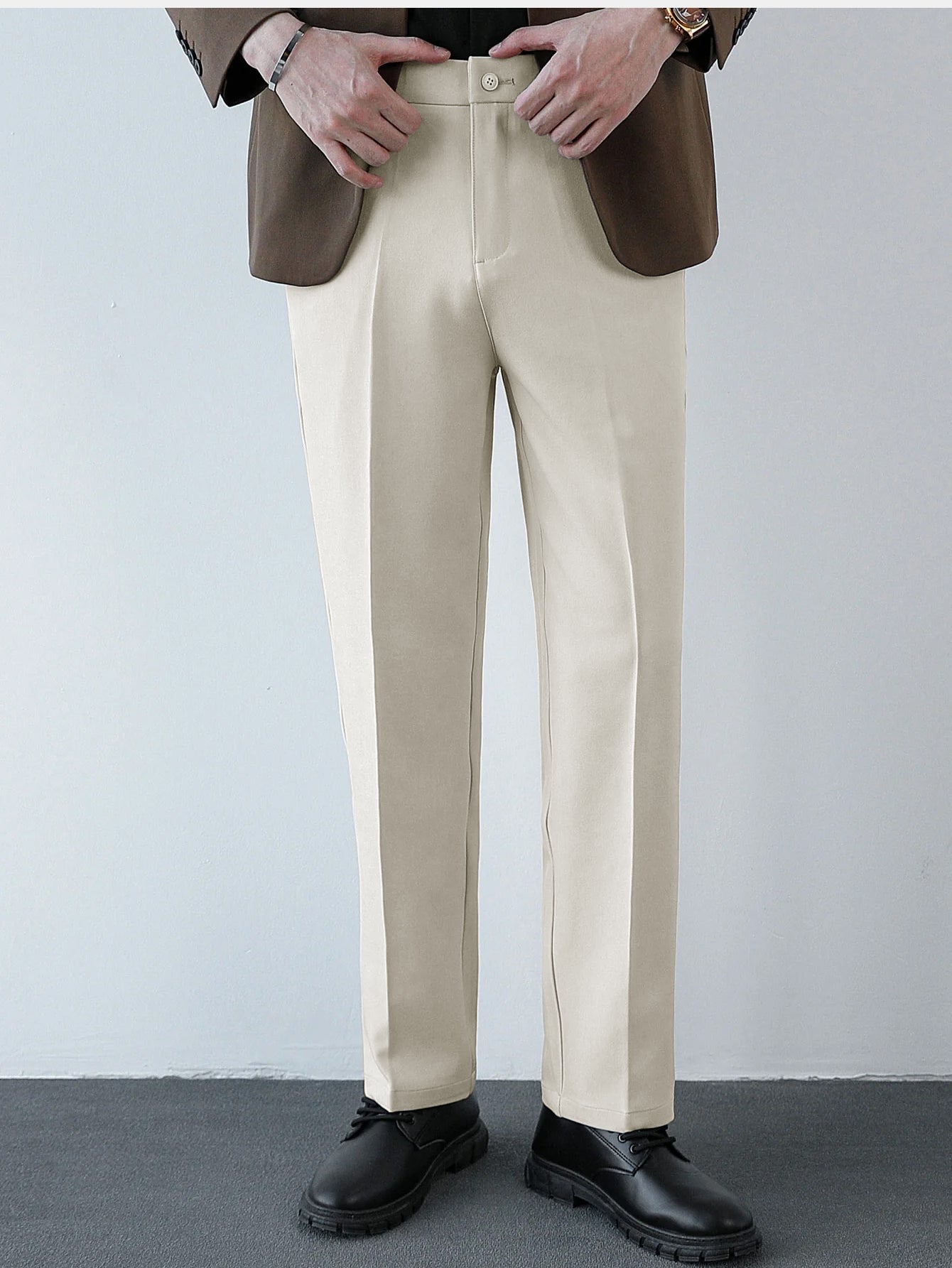 Pantalón regular beige con costuras marcadas y cinturilla con trabillas