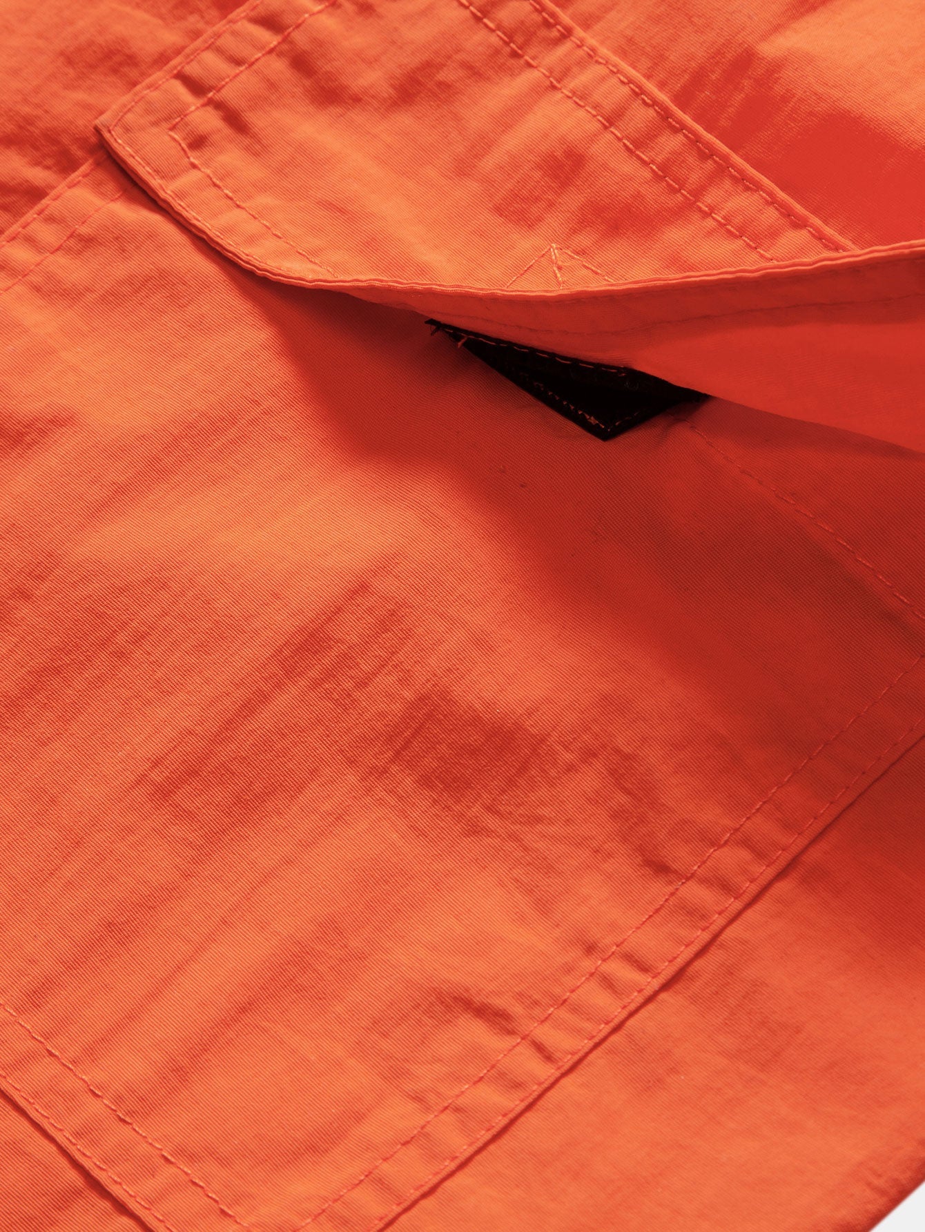 Bañador corto naranja: detalle de costuras y etiqueta interior