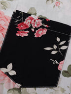 Detalle de panel negro con estampado floral y borde cosido sobre tela clara