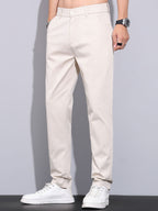 Pantalón recto de color beige, tiro medio, cierre con botón y bolsillos laterales
