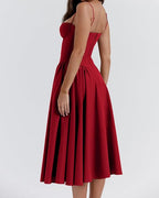 Vestido NOVA rojo con espalda descubierta y tirantes finos, falda plisada midi.