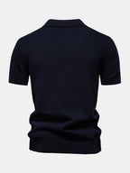 Polo azul marino de manga corta, vista trasera con cuello camisero y bajo fruncido.