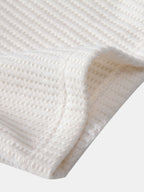 Tejido de rizo en polo crema, textura con relieve y costura en el borde