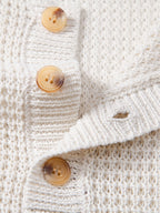 Polo sin mangas crema: detalle de botones y tejido de punto
