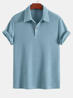 Polo de manga corta azul claro, cuello con tapeta y botones, tejido de rizo