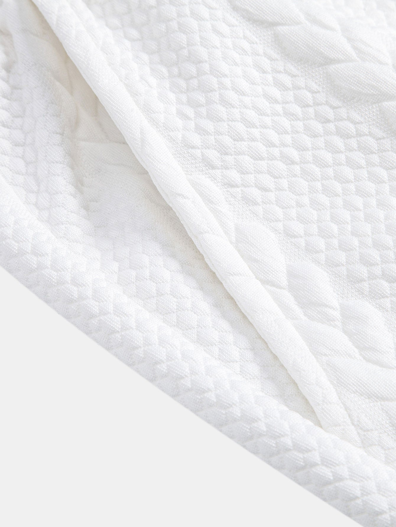 Tela del pantalón corto Capri blanco con textura de relieve en patrón