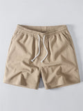Pantalón corto de tela beige con cintura elástica y cordón blanco ajustable