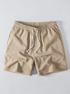 Pantalón corto de tela beige con cintura elástica y cordón blanco ajustable