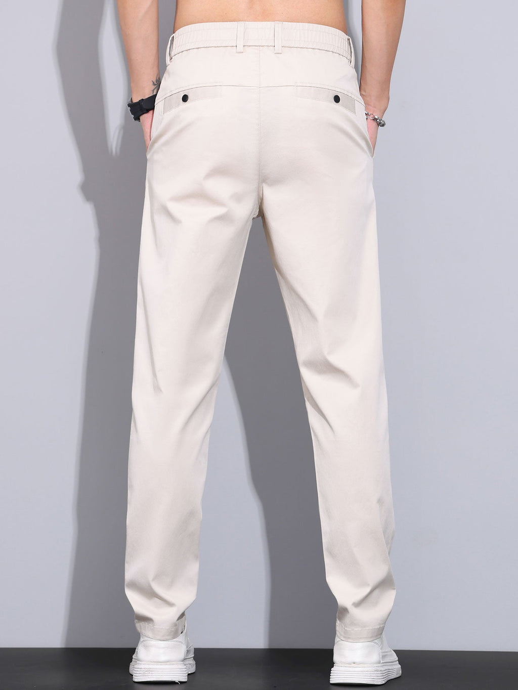 Pantalón recto beige visto por detrás, con cintura elástica y bolsillos traseros