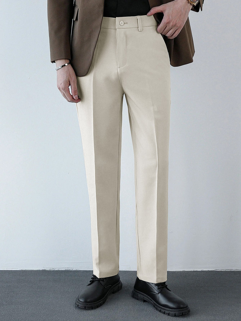 Pantalón regular beige con pinzas y tiro medio, cierre frontal con botón