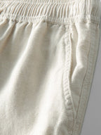 Detalle de pantalón de lino beige con cintura elástica y costuras laterales