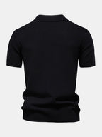 Polo negro de manga corta, vista trasera con cuello camisero y bajo fruncido.