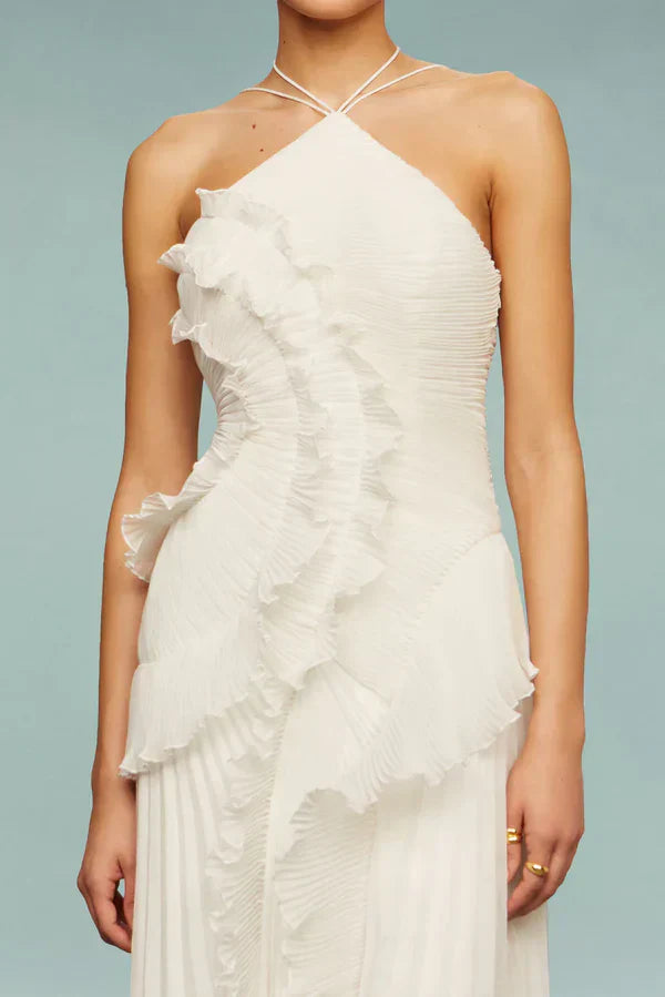 Vestido blanco halter con tirantes cruzados y volantes rizados en el cuerpo.