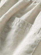 Detalle de pantalón recto de lino beige con bolsillos y costura frontal