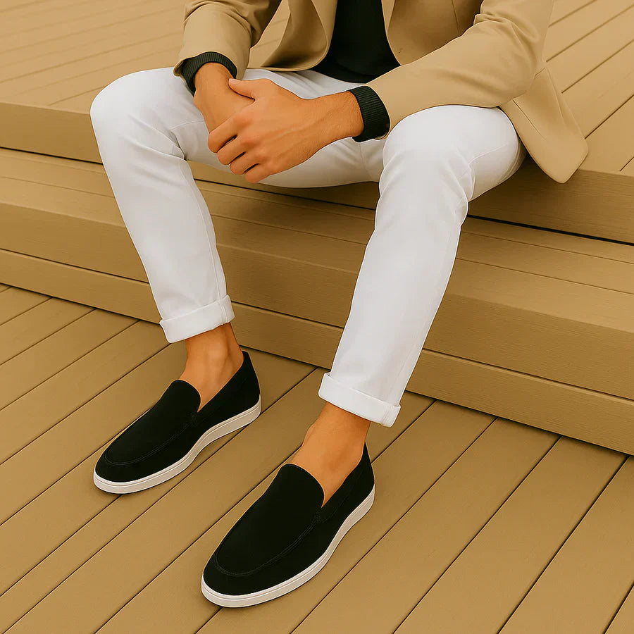 Mocasines casuales de ante negros con suela blanca; usados con pantalón claro