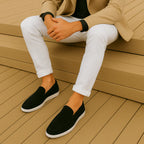 Mocasines casuales de ante negros con suela blanca; usados con pantalón claro