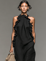 Vestido largo de lino negro con volantes en el escote y drapeado frontal, sin mangas.