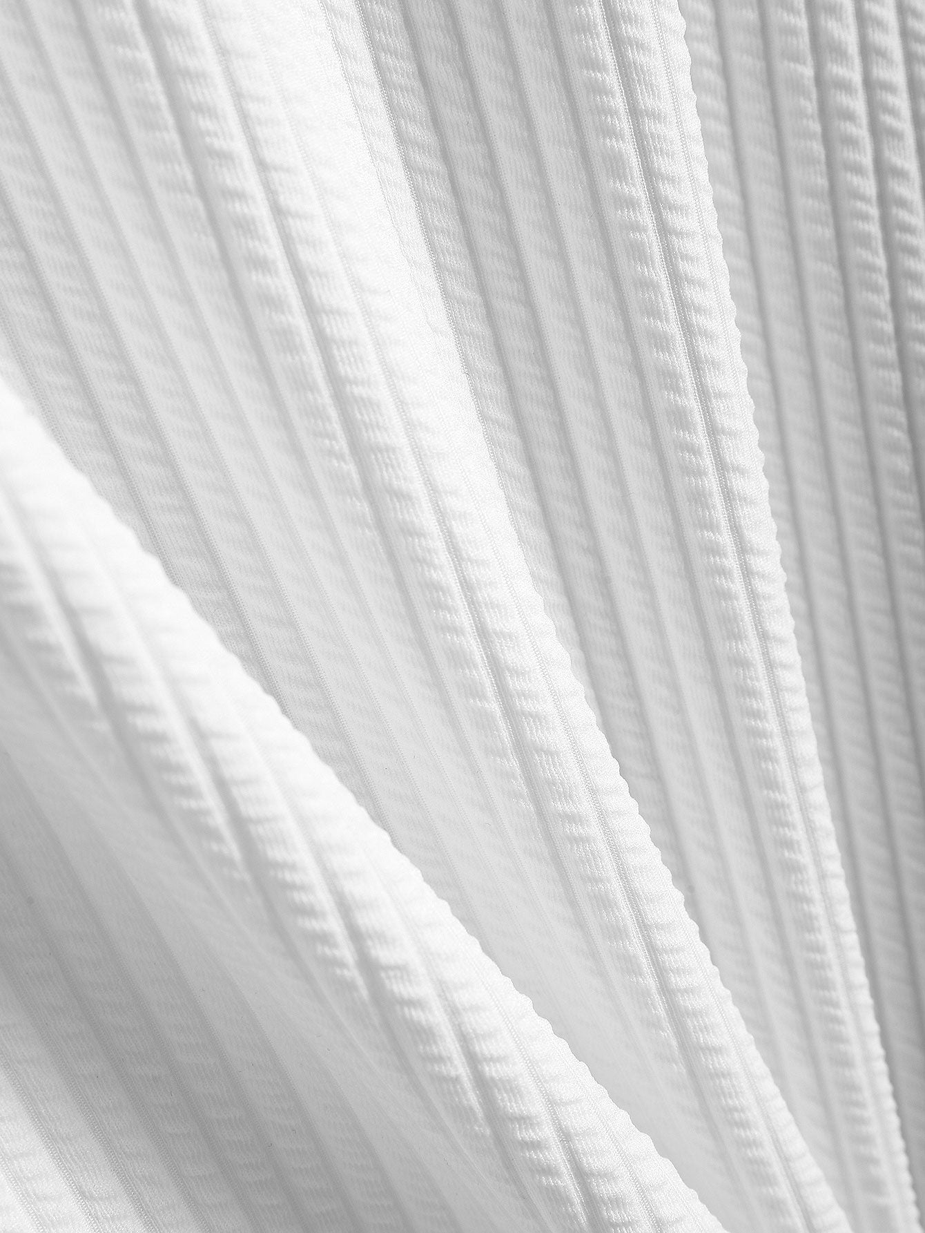 Tela acanalada blanca con textura estriada visible
