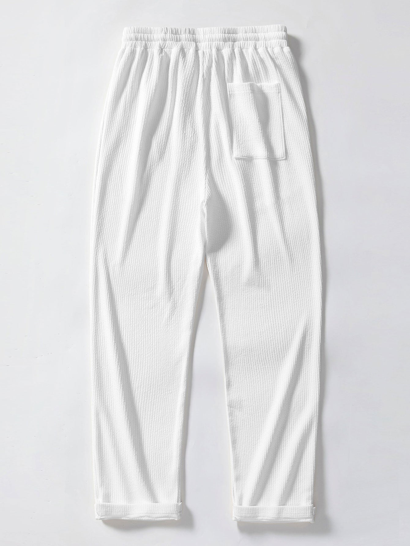 Pantalón recto acanalado blanco con bolsillo y puños elásticos en el bajo