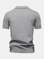 Polo gris claro de manga corta, vista trasera con cuello camisero y bajo fruncido.