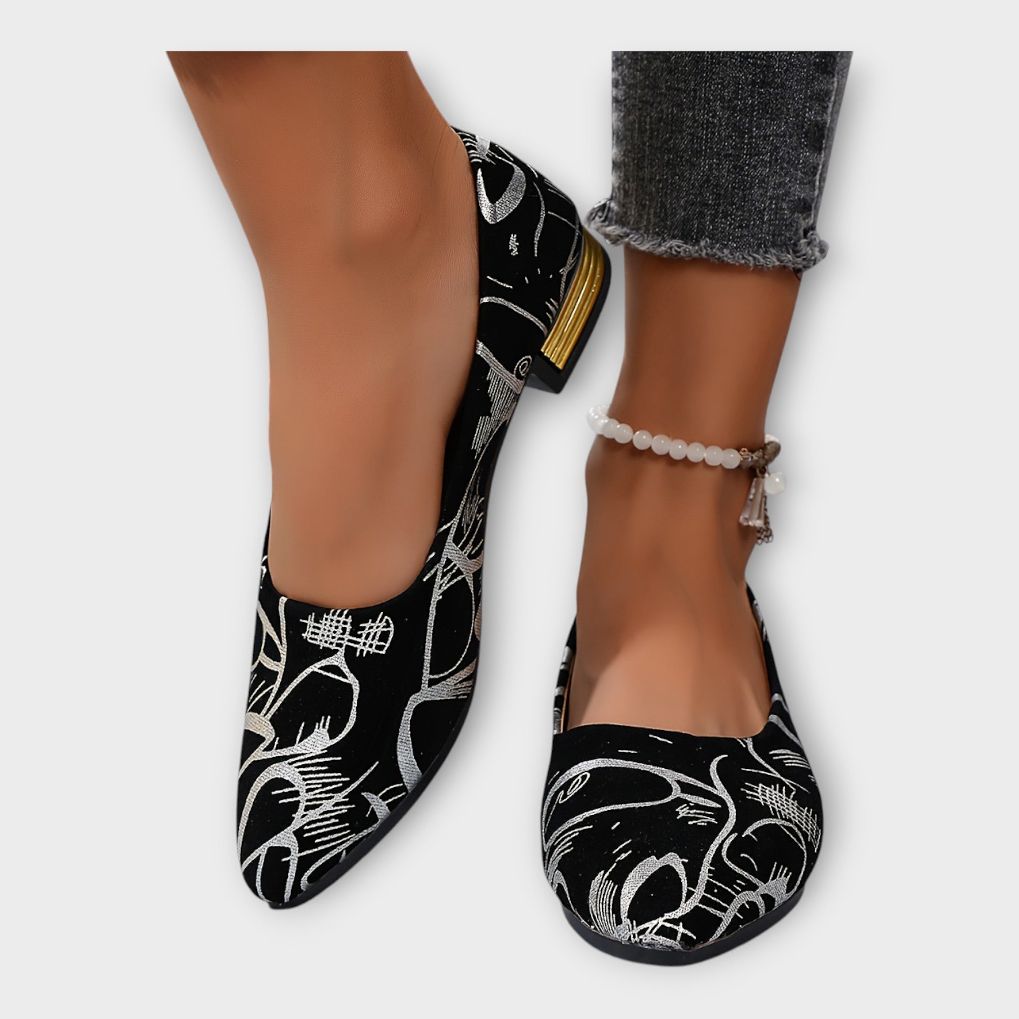 Bailarinas Amélie negras con estampado dorado y tacón ancho bajo; con pulsera de tobillo
