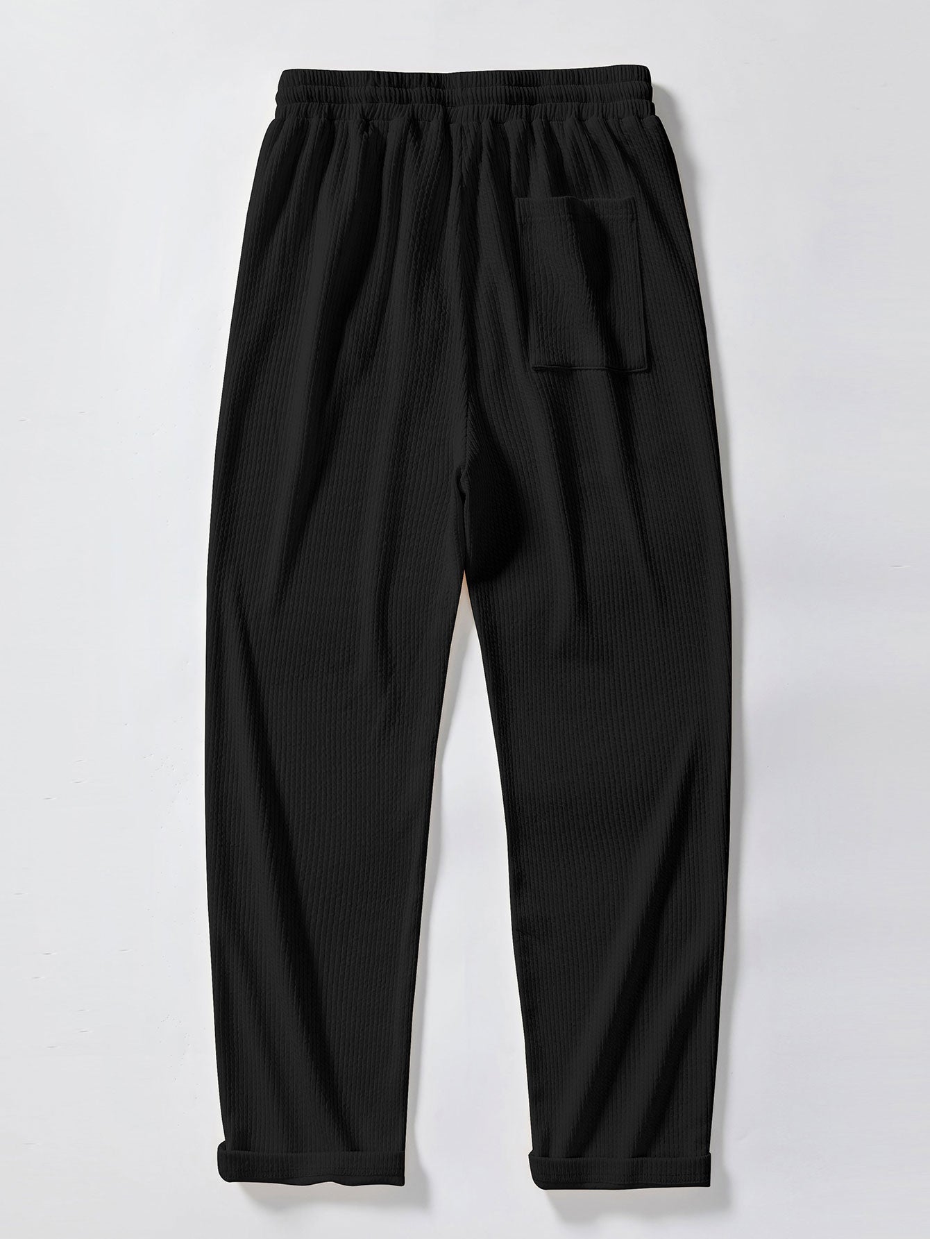 Pantalón recto acanalado negro con bolsillo y puños elásticos en el bajo