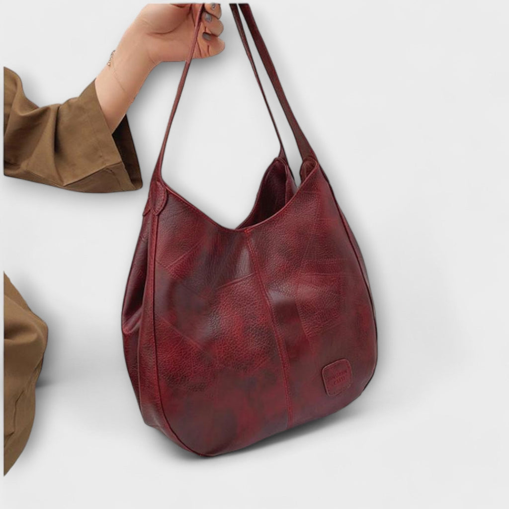 Bolso hobo de piel rojo granate con asas largas y bolsillo delantero con cierre