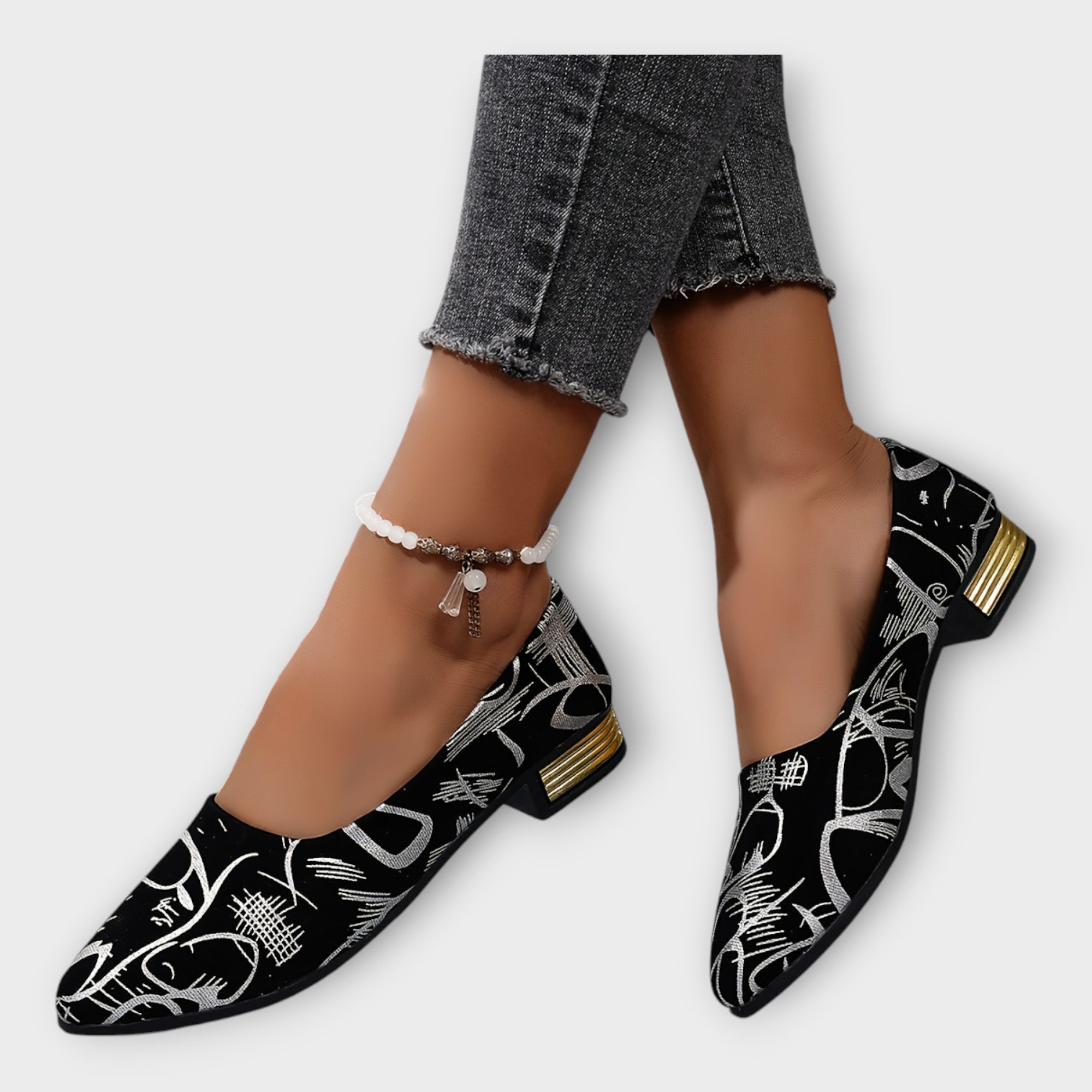 Bailarinas Amélie negras con estampado dorado y tacón ancho bajo; con pulsera de tobillo