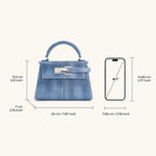 Bolso azul con asa superior y cierre metálico rectangular, vista frontal