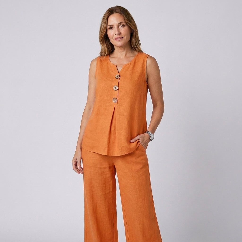 Conjunto fluido con top sin mangas y pantalón ancho, color naranja, botones al frente.