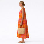 Vestido midi sin mangas estampado naranja y rosa, vista lateral con dobladillo a media pierna