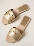 Sandalias Sublim doradas metalizadas con pulsera cruzada y suela beige.
