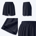 Shorts azul marino plisados con cintura elástica y bajo redondeado, detalle de tela