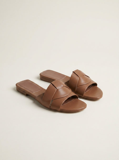 Sandalias Sublim marrón con dos tiras anchas cruzadas y suela plana.