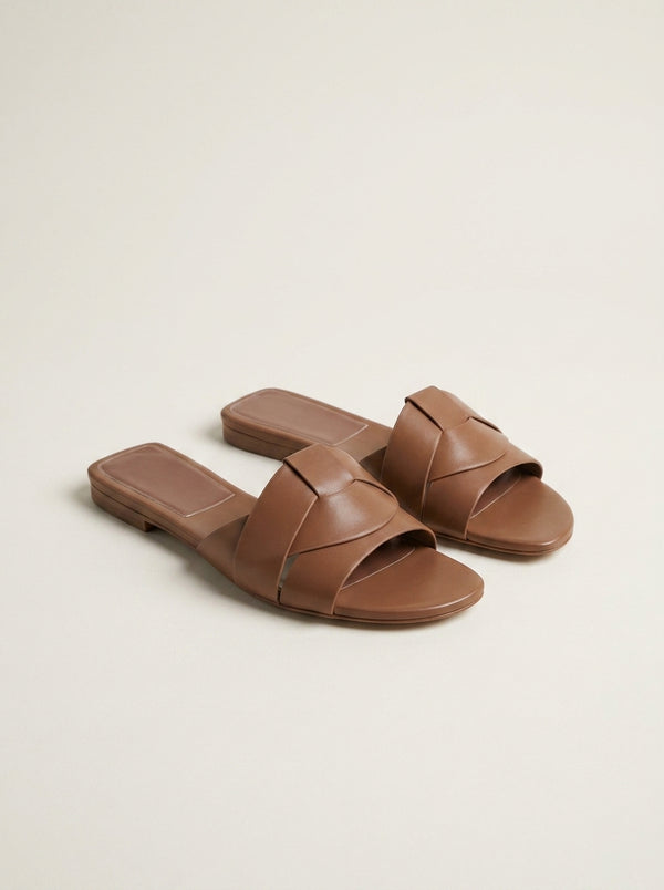 Sandalias Sublim marrón con dos tiras anchas cruzadas y suela plana.