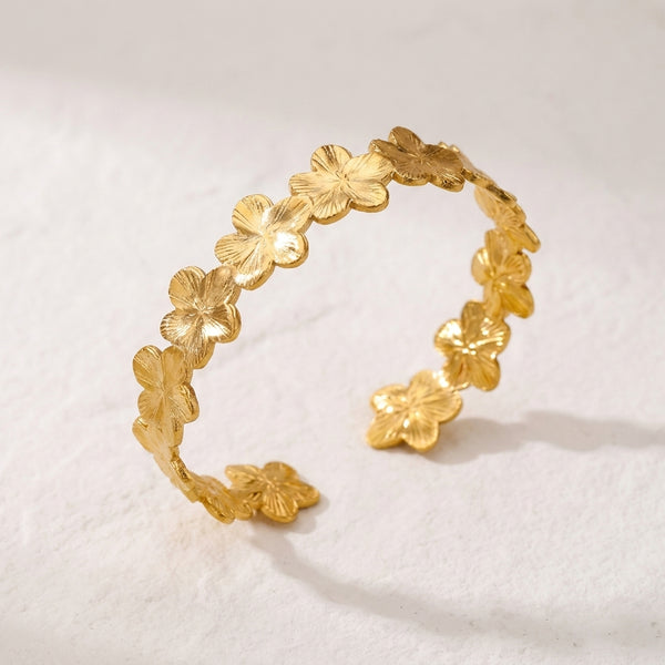 Brazalete dorado con flores de cuatro pétalos en acabado brillante