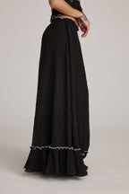 Falda maxi negra con textura plisada y volante inferior con ribete claro