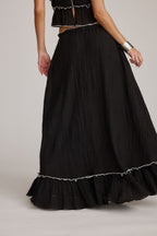 Falda negra maxi con costuras decorativas y bajo con volantes ribeteados