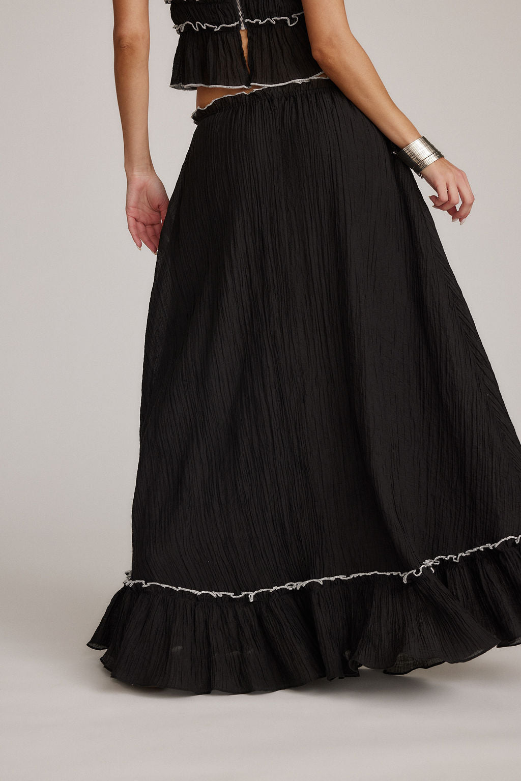 Falda negra maxi con costuras decorativas y bajo con volantes ribeteados