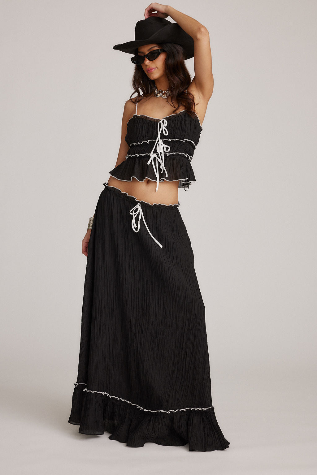Conjunto de falda y top negro con volantes y cordones blancos en el pecho