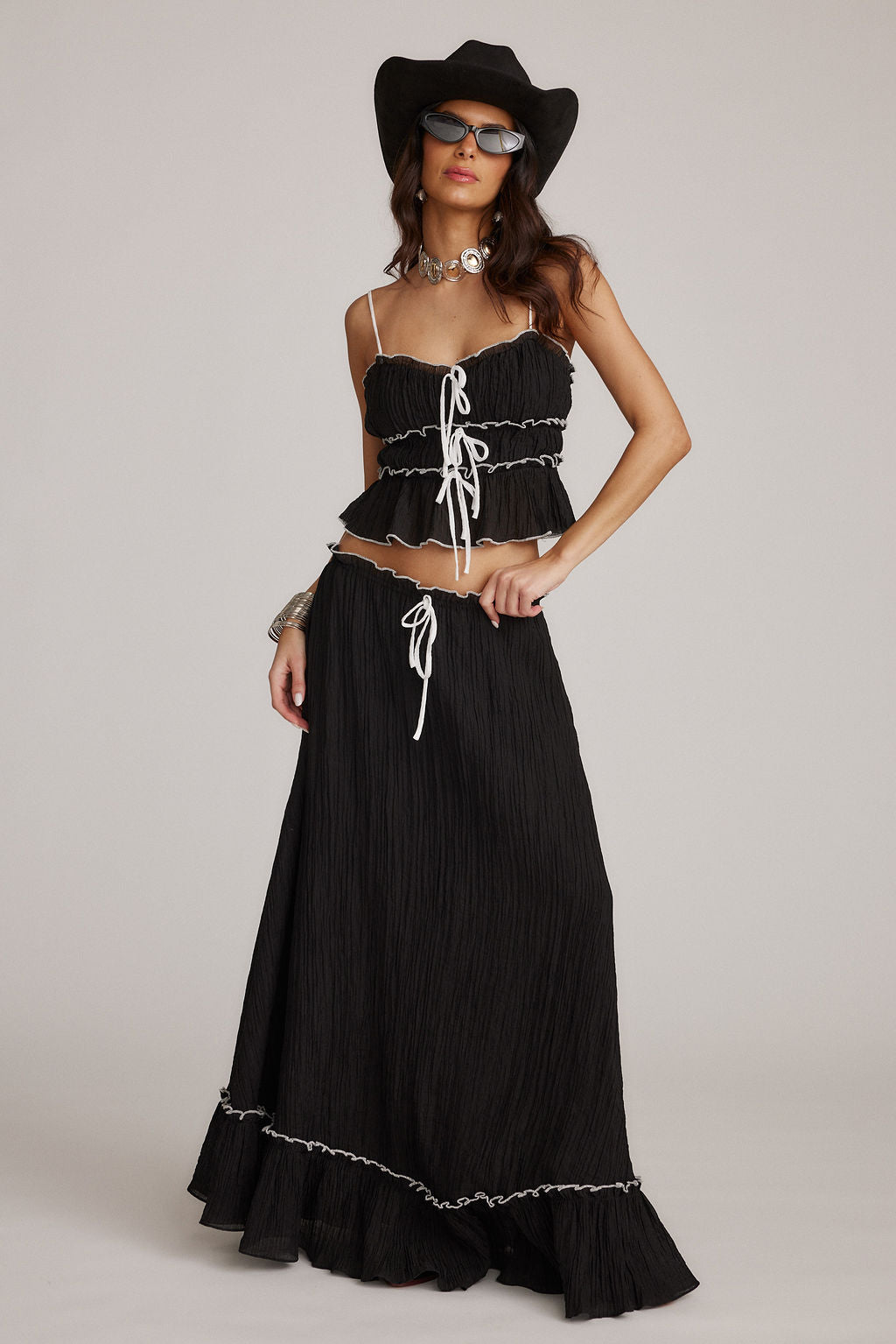Conjunto negro de top con tirantes y falda larga con ribete ondulado y cordones
