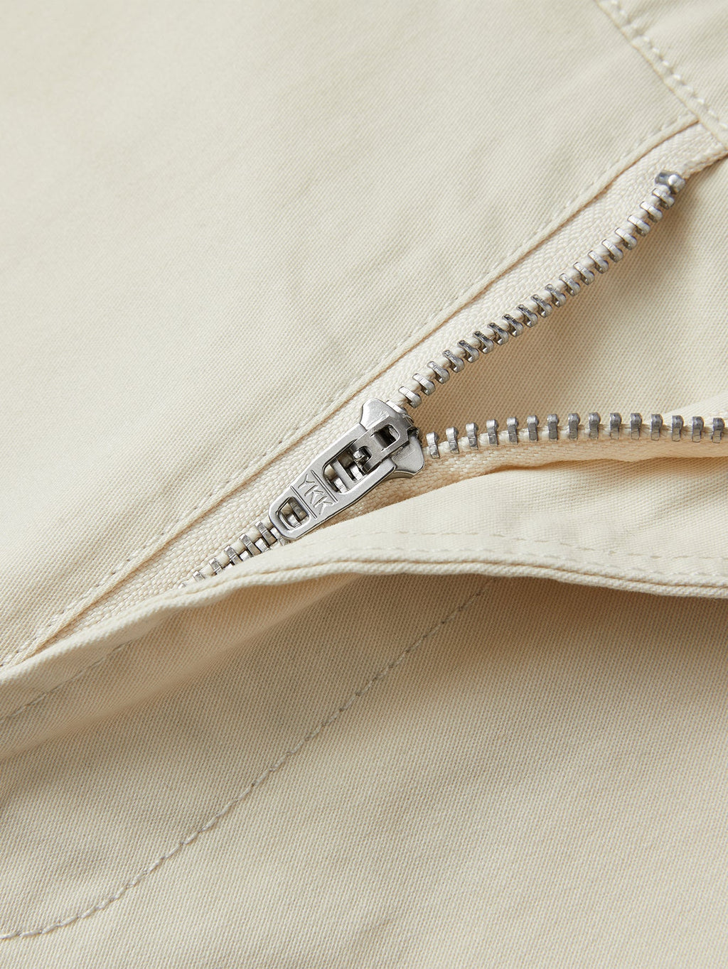 Pantalón corto beige con cremallera metálica y costura en la bragueta