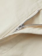 Pantalón corto beige con cremallera metálica y costura en la bragueta