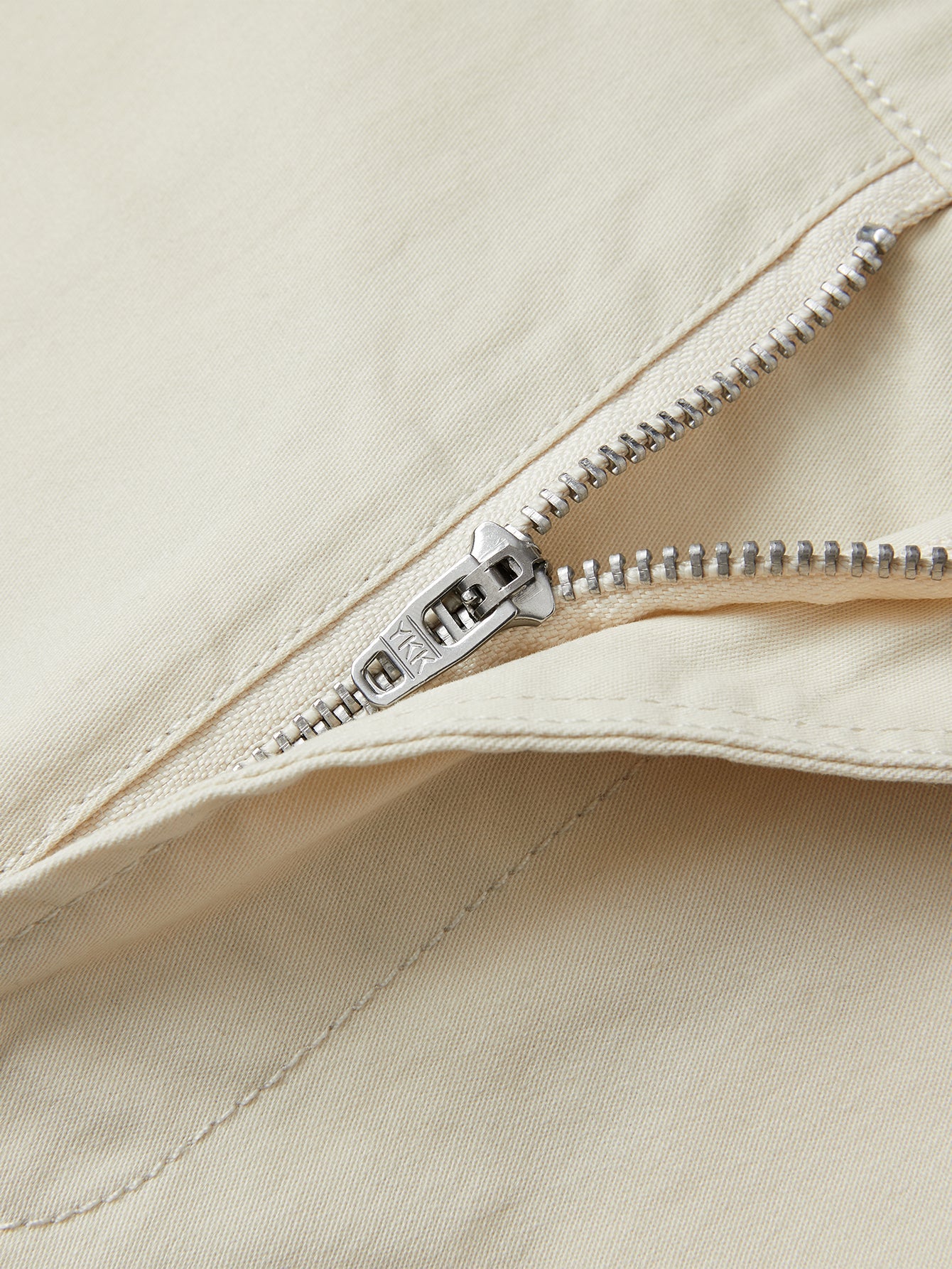 Pantalón corto beige con cremallera metálica y costura en la bragueta