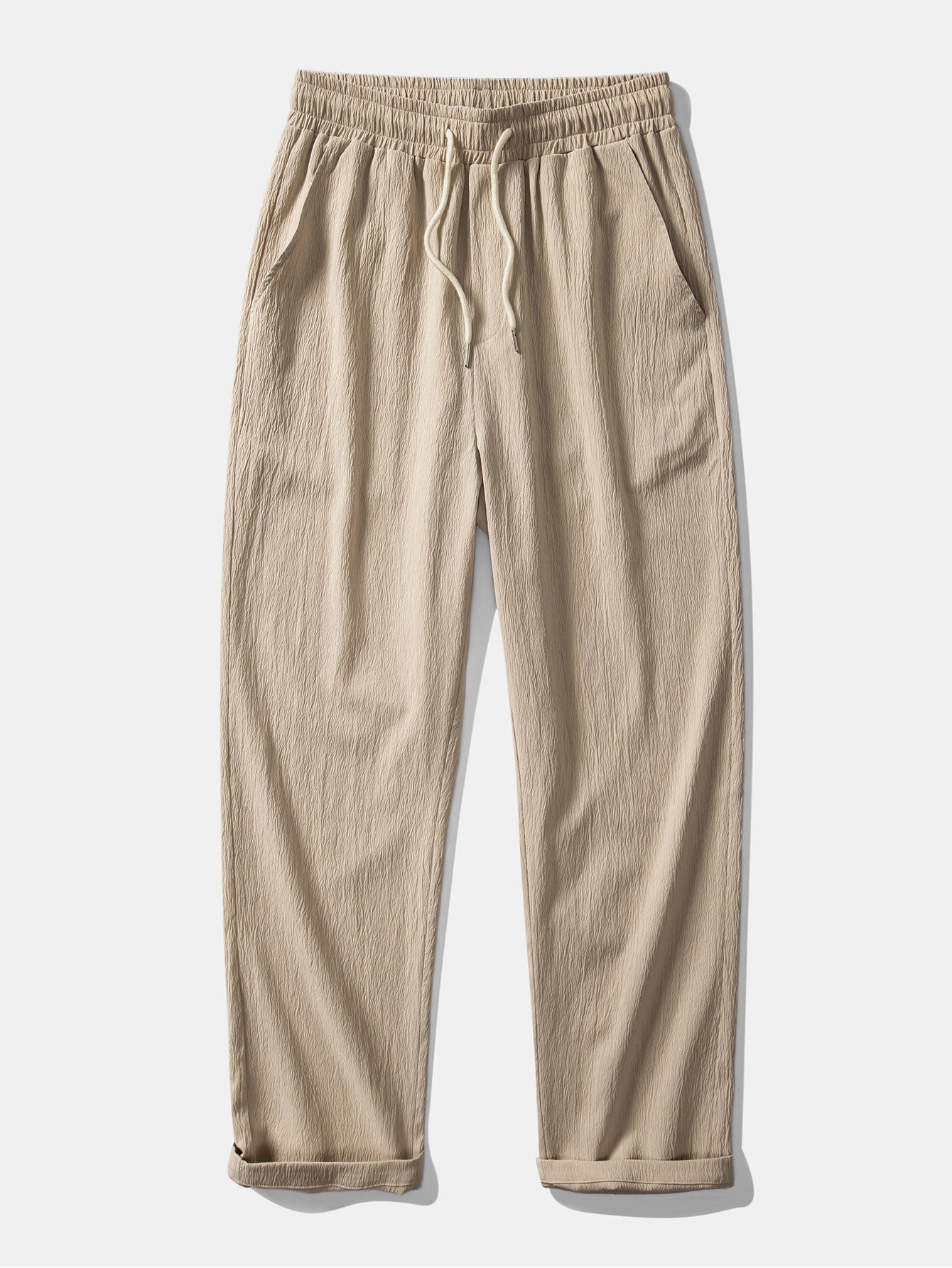Pantalón recto beige con cintura elástica y cordón, textura arrugada y puños doblados
