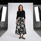 Falda plisada larga negra con estampado floral blanco, cintura elástica y caída amplia