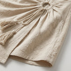 Falda corta de interior color beige, recogido con lazo y flecos laterales