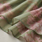 Tela de vestido con estampado floral en tonos verde y rosa, tejido ligero y plisado.