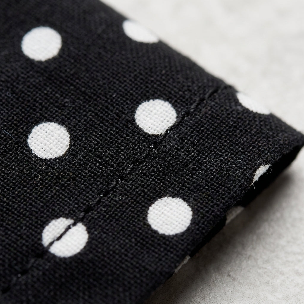 Tela de vestido negro con lunares blancos, detalle de tejido